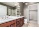 This updated bathroom features a double vanity, and glass shower at 9633 E 5Th Ave # 10304, Denver, CO 80230
