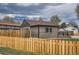 Backyard with green grass and wood fence featuring a cozy wooden patio at 6000 Yarrow St, Arvada, CO 80004
