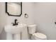 Half bath with white pedestal sink, black fixtures and a modern mirror at 6000 Yarrow St, Arvada, CO 80004