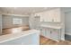 Open kitchen view with white cabinets, gray lowers, and hardwood flooring at 6000 Yarrow St, Arvada, CO 80004