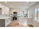 Open kitchen with modern appliances, bright white cabinets, and eat-in bar at 6000 Yarrow St, Arvada, CO 80004