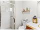 Cozy bathroom featuring a tiled shower, cute decor on the toilet, and a wood shelf with plants at 1050 Youngfield St, Golden, CO 80401