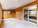 Bright sunroom featuring wood paneling, neutral carpeting, and access to the backyard at 1050 Youngfield St, Golden, CO 80401