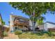 This backyard features an elevated deck, a storage shed, a beautiful tree, and grass at 11200 W 102Nd Ave, Broomfield, CO 80021