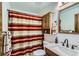 Traditional bathroom featuring a classic sink, a toilet, and a shower with a striped curtain at 11200 W 102Nd Ave, Broomfield, CO 80021