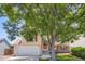 Two-story house featuring neutral siding, red shutters, two-car garage and mature tree at 11200 W 102Nd Ave, Broomfield, CO 80021
