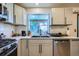 Updated kitchen with stainless appliances, light gray cabinets, and a large window at 11200 W 102Nd Ave, Broomfield, CO 80021