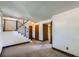 Well-lit living room featuring stairs with black railing and multiple doors at 11200 W 102Nd Ave, Broomfield, CO 80021
