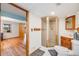 Bathroom featuring a glass enclosed shower and access to bedroom with wood floors at 163 Ward Ct, Lakewood, CO 80228