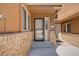 Well-maintained front entry with brick accents and a screened front door with house number 163 at 163 Ward Ct, Lakewood, CO 80228