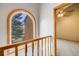 Hallway with railing, arched window, and view into another room at 163 Ward Ct, Lakewood, CO 80228