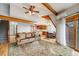 Open living space with hardwood floors, natural light, wood beams, and living and dining areas at 163 Ward Ct, Lakewood, CO 80228