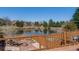 A beautiful pond-side view showcases mature trees and landscaping from the outdoor deck at 163 Ward Ct, Lakewood, CO 80228