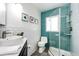 Modern bathroom with blue tile in the shower, white subway tile and updated fixtures at 2039 S Sherman St, Denver, CO 80210