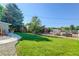 Large backyard with green lawn and barn in the distance at 9852 Zephyr Dr, Broomfield, CO 80021