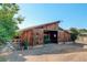 A large wooden barn with open doors, surrounded by sand and foliage at 9852 Zephyr Dr, Broomfield, CO 80021