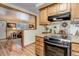 Kitchen view with stainless steel oven, and views to the adjacent living room and dining nook at 9852 Zephyr Dr, Broomfield, CO 80021