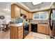 Functional kitchen with wood cabinets, black appliances, and natural light at 9852 Zephyr Dr, Broomfield, CO 80021