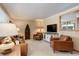Cozy living room featuring leather furniture, neutral carpet, and a rustic decorative shelving unit at 9852 Zephyr Dr, Broomfield, CO 80021