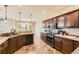Kitchen with dark wood cabinetry, tile backsplash, and stainless steel appliances at 9023 Apache Plume Dr # D, Parker, CO 80134
