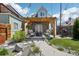 Landscaped backyard featuring a cozy pergola-covered patio, lush lawn, and decorative stone pathways at 3207 N Marion St, Denver, CO 80205
