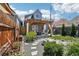 Charming backyard featuring a pergola with seating, lush greenery, and a decorative stone walkway at 3207 N Marion St, Denver, CO 80205