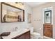 Well-lit bathroom features a modern vanity, eye-catching mirror, and unique brick accents at 3207 N Marion St, Denver, CO 80205