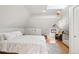Comfortable attic bedroom features a skylight, wooden floors, and neutral decor at 3207 N Marion St, Denver, CO 80205