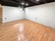 Unfinished basement showcasing wood flooring and black ceiling at 16841 E Mansfield Cir, Aurora, CO 80013