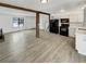 Open-concept living room showcases wood beams and flows into a kitchen with modern appliances at 16841 E Mansfield Cir, Aurora, CO 80013