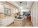 Bright kitchen featuring white cabinets, an island with cooktop, and an open layout into the living space at 8853 N Awl Rd, Parker, CO 80138