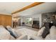 Cozy living room with a stone fireplace, wood beam, plush sofas, and a view into the well-equipped kitchen at 8853 N Awl Rd, Parker, CO 80138