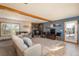 Inviting living room boasts a stone fireplace, wood beams, and access to a deck at 8853 N Awl Rd, Parker, CO 80138