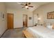 Bright main bedroom featuring neutral tones, vaulted ceiling with fan, and ensuite bathroom at 8853 N Awl Rd, Parker, CO 80138