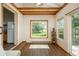 Bright sunroom featuring wood beam accents, large windows with backyard views, and wood flooring at 8853 N Awl Rd, Parker, CO 80138