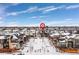 Modern townhome community nestled amongst other homes, snow covered landscaping at 6860 E Lowry Blvd, Denver, CO 80230