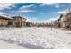 Snow covered community features modern townhomes and open green space at 6860 E Lowry Blvd, Denver, CO 80230