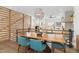 Modern dining area with wood table and blue chairs, located near staircase and kitchen at 6860 E Lowry Blvd, Denver, CO 80230