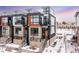 Modern three-story townhome with attached two-car garage, snow covered landscaping at 6860 E Lowry Blvd, Denver, CO 80230