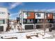 Modern townhome with attached two-car garage, snow covered landscaping at 6860 E Lowry Blvd, Denver, CO 80230