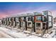 Modern townhome community with attached two-car garages, snow covered landscaping at 6860 E Lowry Blvd, Denver, CO 80230