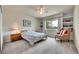 Cozy bedroom with a bed, side table, chair and bookshelf in a neutral color scheme at 10653 W Parkhill Dr, Littleton, CO 80127