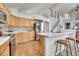 Modern kitchen featuring stainless steel appliances, a center island with bar seating and tiled floors at 10653 W Parkhill Dr, Littleton, CO 80127