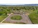 Aerial view of a community garden with individual plots, a playground, and circular driveway at 12992 W Jewell Cir, Lakewood, CO 80228