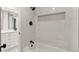 Bathroom with white marble wall tile, black hardware, and a built-in shelving niche at 12992 W Jewell Cir, Lakewood, CO 80228