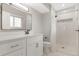 Bright bathroom with a shower featuring stylish white tile and a glass door, plus a modern vanity at 12992 W Jewell Cir, Lakewood, CO 80228