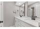 Modern bathroom featuring a double vanity with a sleek countertop and two mirrors at 12992 W Jewell Cir, Lakewood, CO 80228