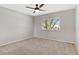 Cozy bedroom with neutral walls, carpet flooring, ceiling fan, and a window that fills the room with natural light at 12992 W Jewell Cir, Lakewood, CO 80228