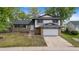 Inviting two-story house boasts a brick facade, a lush green lawn, and an attached two-car garage at 12992 W Jewell Cir, Lakewood, CO 80228