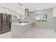 Bright kitchen boasts stainless steel appliances, a large island, and marble floors at 12992 W Jewell Cir, Lakewood, CO 80228